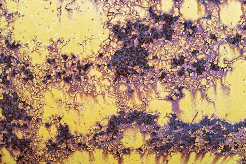 The rust and peeling yellow paint on the surface of an antique tractor royalty free stock photo