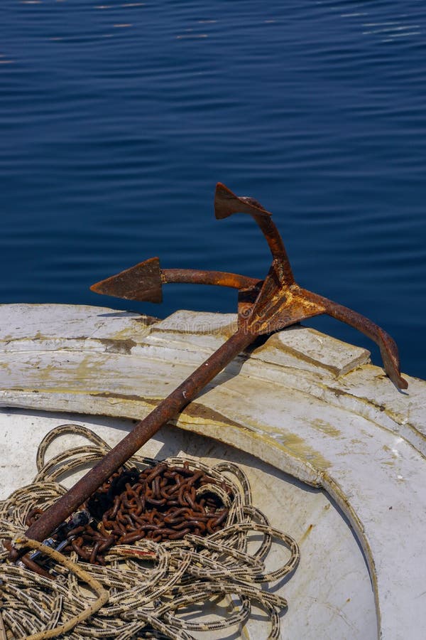 Rusted Anchor Attached To the Rope on the Boat Portrait Stock Photo