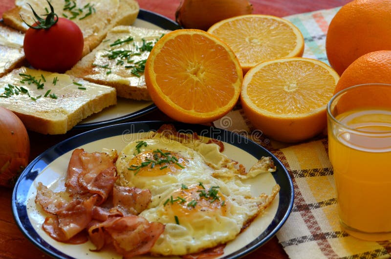 Rustic Breakfast Roasted Bread with Butter and Chives, Fried Eggs and Bacon. Stock Image