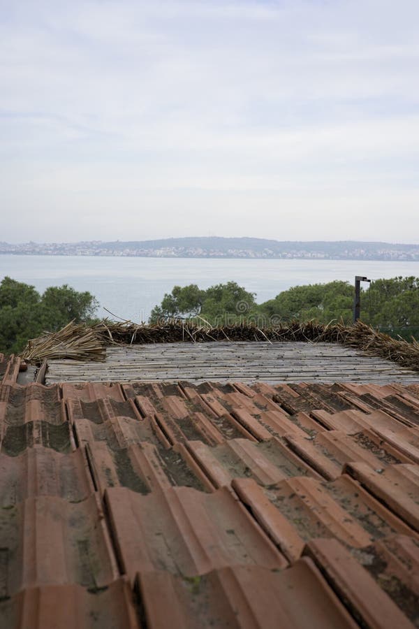 Rustic brown tile roof and sea view stock photography