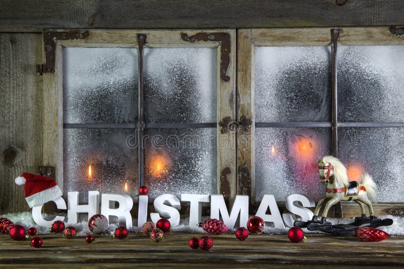 Rustic christmas window with red candles, horse and greeting tex