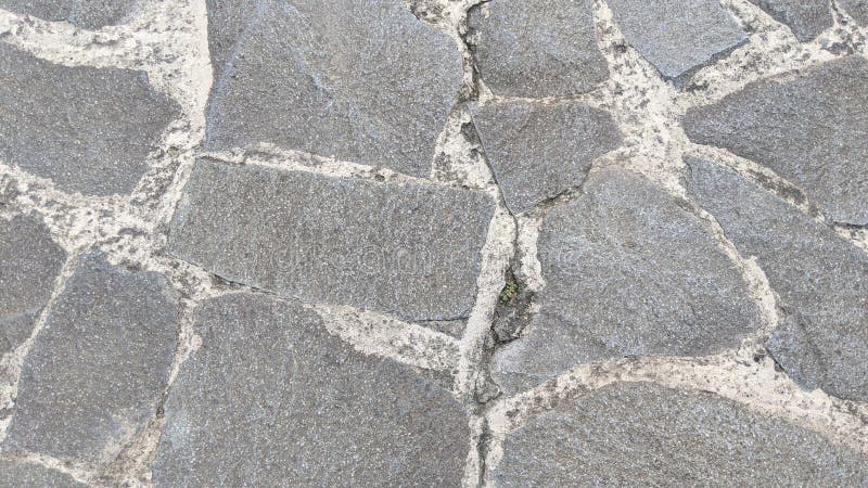 Rustic grey flagstone paving with irregular shapes and rough textures, set with light-colored mortar, forming stock images
