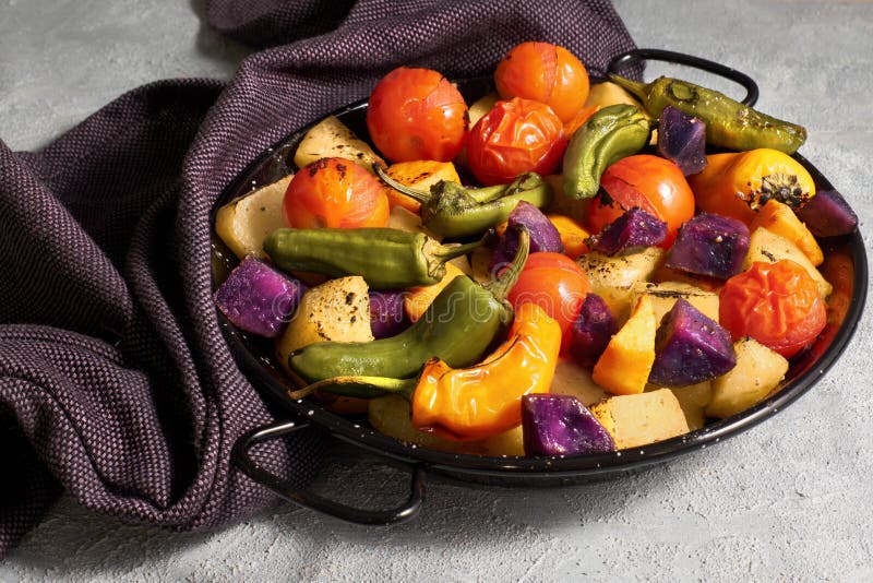 Rustic oven baked vegetables in black baking dish cooling on on dark towel on light gray concrete background royalty free stock photos Rustic oven baked vegetables in black baking dish cooling on on dark towel on light gray concrete background royalty free stock photos