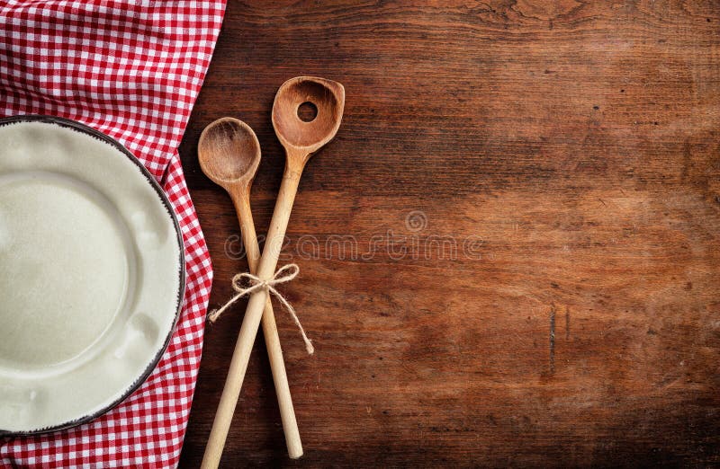 Empty plate, kitchen utensils and red tablecloth on wooden table, top view, copy space stock image Empty plate, kitchen utensils and red tablecloth on wooden table, top view, copy space stock image
