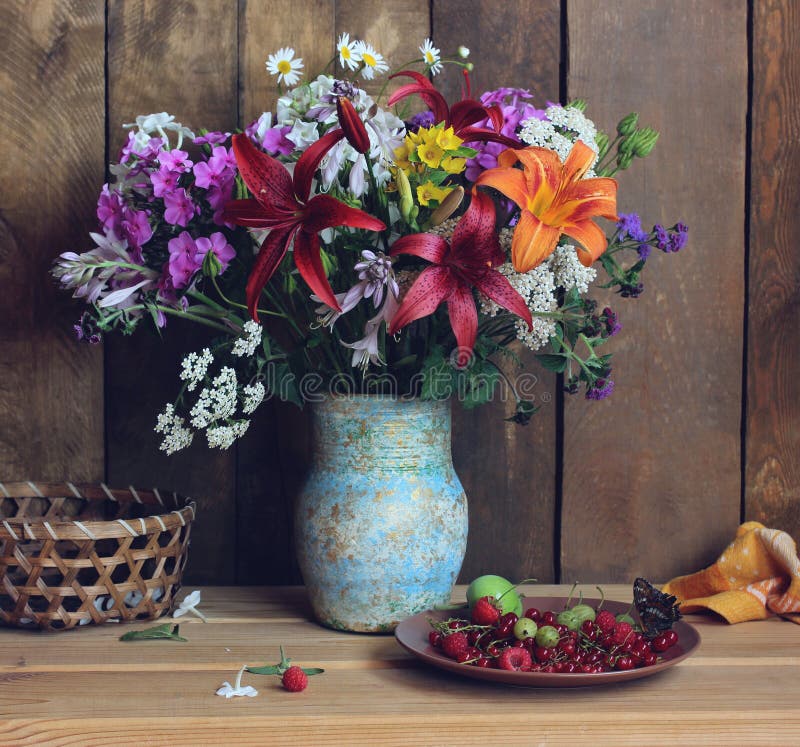 Rustic still life with flowers and berries summer bouquet of phlox lilies daisies
