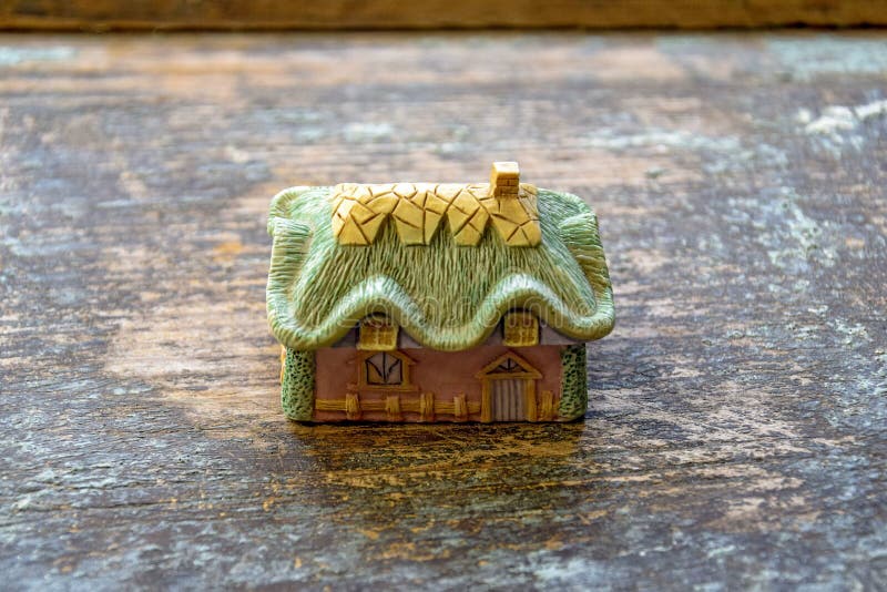 Rustic style: a small colorful toy village house on an old wooden surface with remnants of blue paint. Close-up. Copy space royalty free stock photos Rustic style: a small colorful toy village house on an old wooden surface with remnants of blue paint. Close-up. Copy space royalty free stock photos