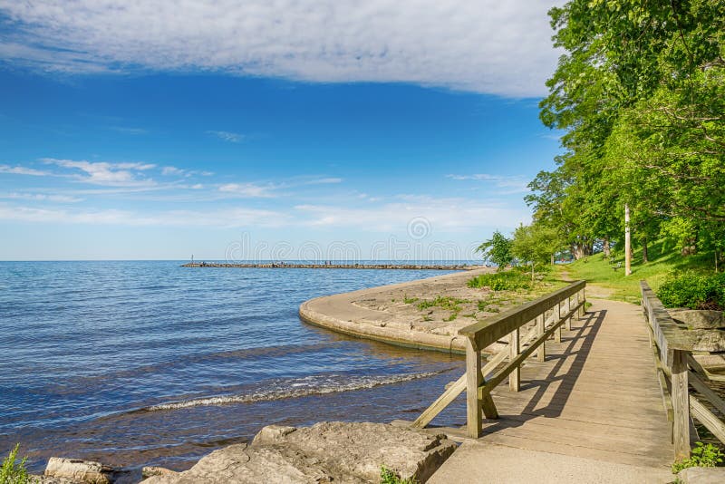 Rustic wooden bridge and lake Ontario. Blue sky. Rochester, USA