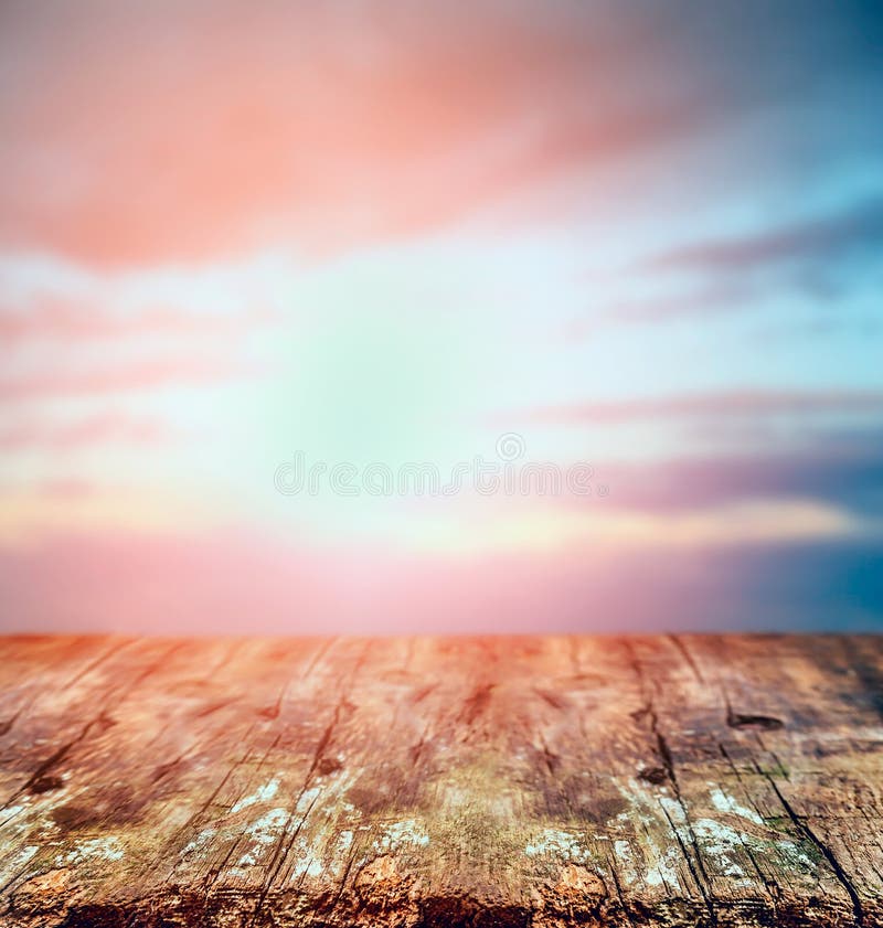 Rustic wooden table over sunset sky, nature background.