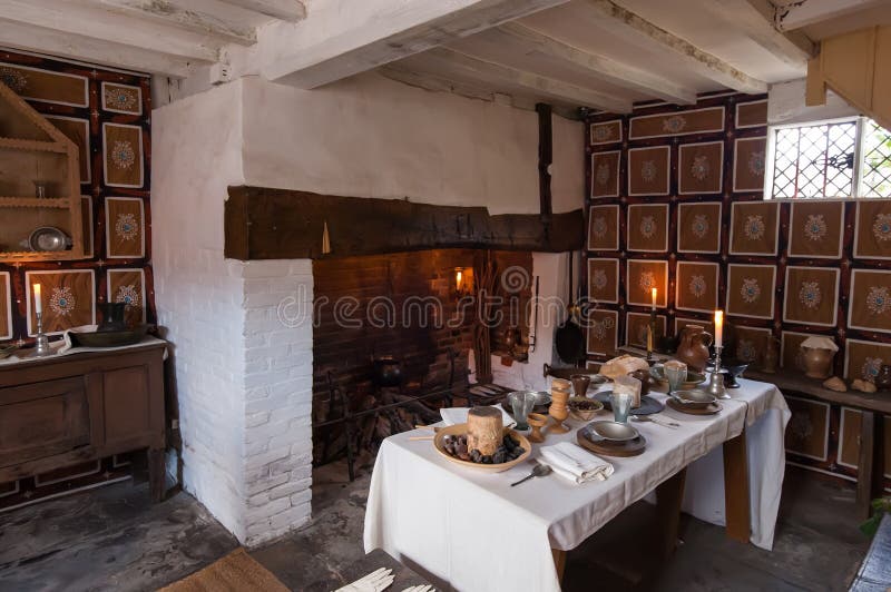 Interior of an old country cottage with fireplace and rustic table set for a breakfast. Interior of an old country cottage with fireplace and rustic table set for a breakfast.