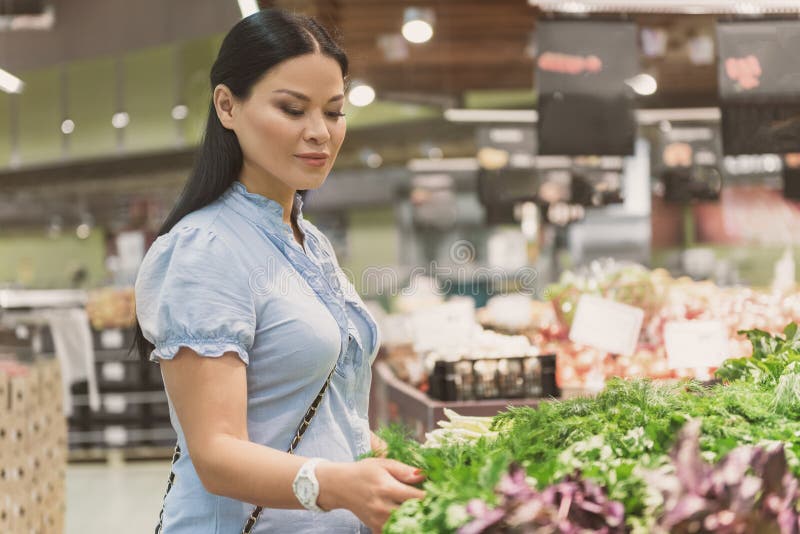 Rustige vrouwelijke makende keus van groene groenten stock afbeeldingen Rustige vrouwelijke makende keus van groene groenten stock afbeeldingen