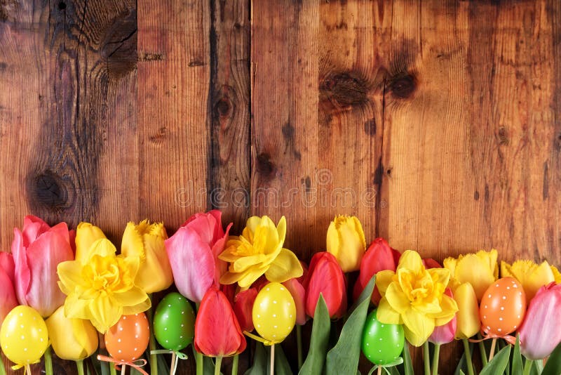 Rustikaler Hintergrund Ostern Rosa und gelbe Tulpen und Narzissenblumen in der Reihe auf alten hölzernen Planken lizenzfreies stockfoto Rustikaler Hintergrund Ostern Rosa und gelbe Tulpen und Narzissenblumen in der Reihe auf alten hölzernen Planken lizenzfreies stockfoto