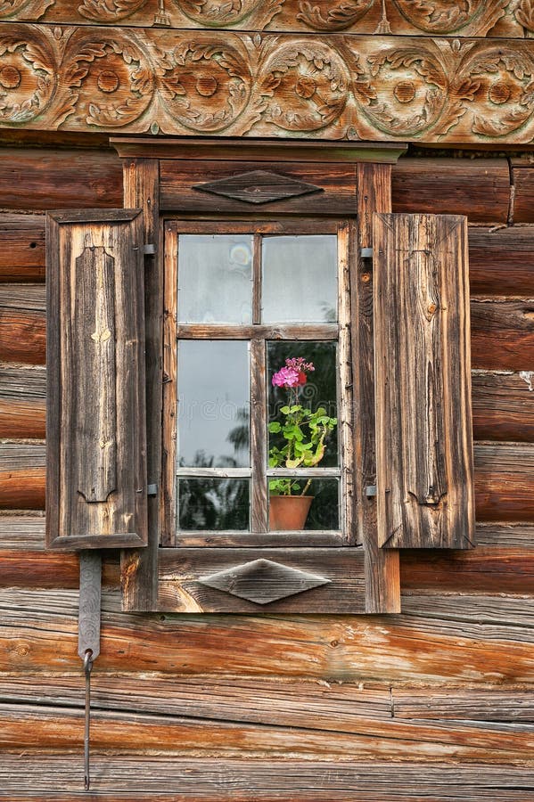 Rustikales Holzfenster mit antiken Fensterläden verleiht dem Haus einen zauberhaften Charme stockbild