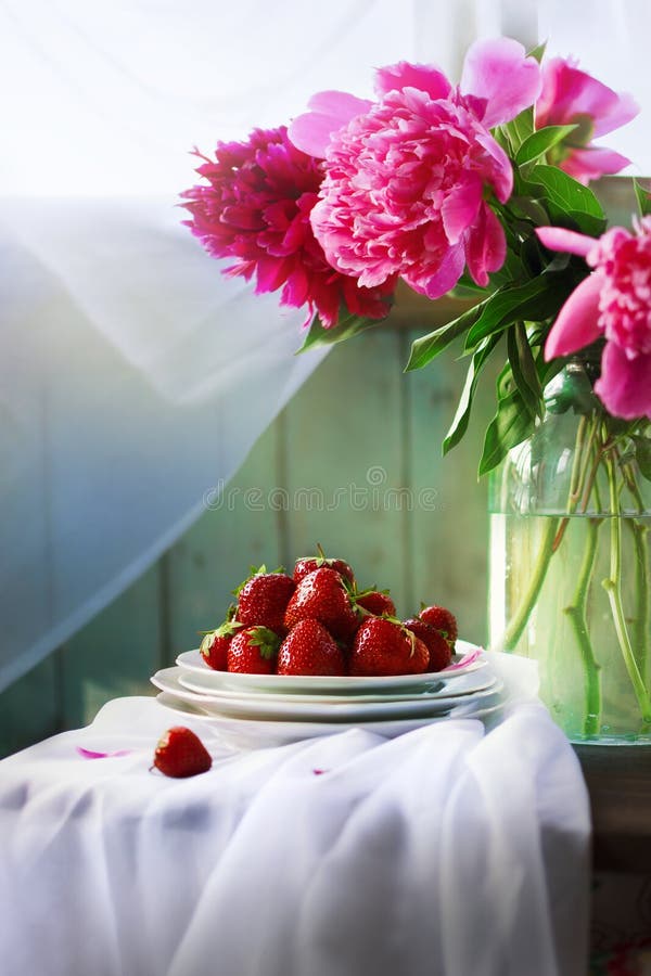 Rustikales Stillleben des Sommers mit Erdbeer- und Pfingstrosenblumenstrauß stockbild Rustikales Stillleben des Sommers mit Erdbeer- und Pfingstrosenblumenstrauß stockbild