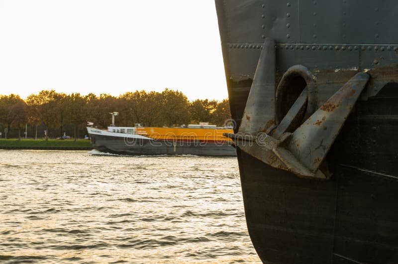Rusty anchor is hanging on a black industrial ship stock images Rusty anchor is hanging on a black industrial ship stock images