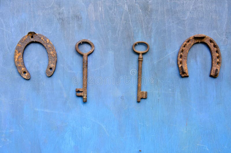 Rusty ancient key and horseshoe hang on wooden barn wall royalty free stock photography