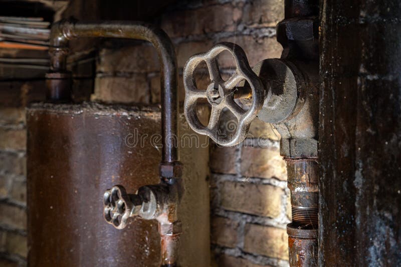 Rusty boiler room pipes. Old metal boiler generating heating and delivering it to home through pipeline. Hot water or gas is being