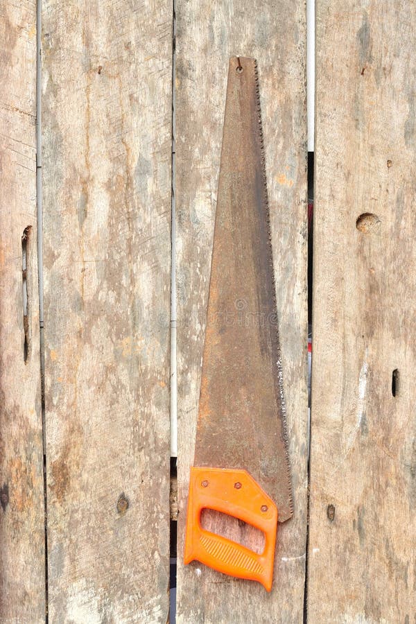 Rusty hand saw on wooden board royalty free stock image
