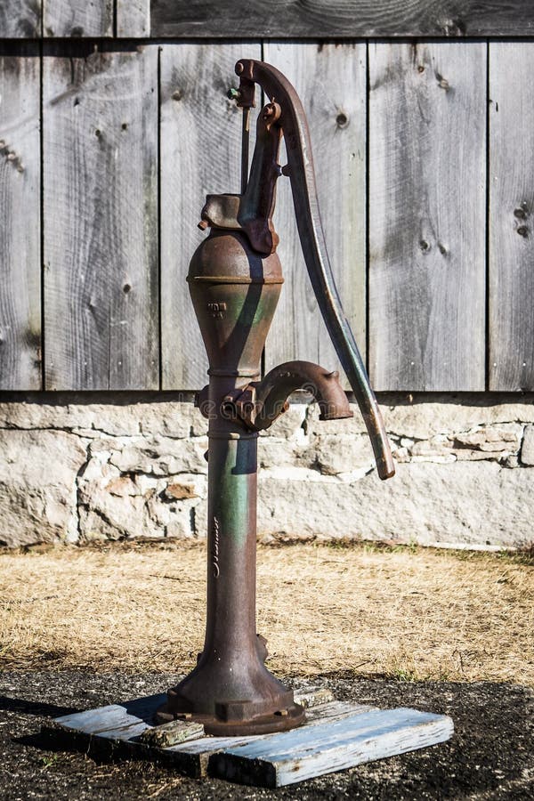 Rusty Hand Water Pump and Old Barn Boards royalty free stock photo