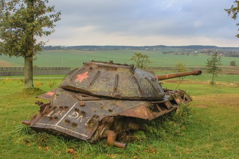 A rusty heavy Soviet IS-3 tank without tracks is rusting in the field