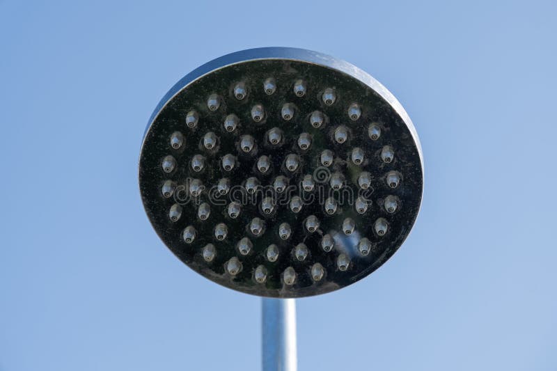 Rusty and limescale shower head on a blue sky background stock photo