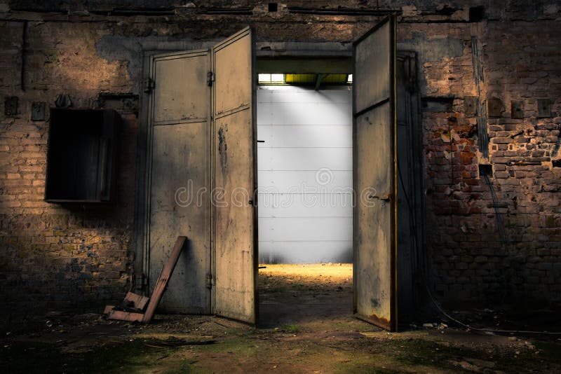 Rusty metal door in an abandoned warehouse royalty free stock image