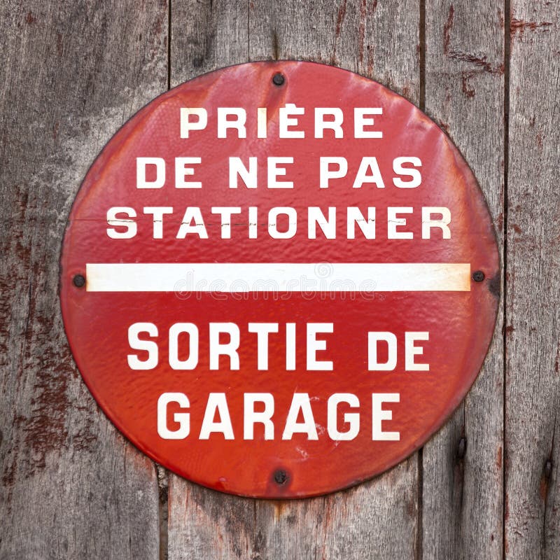 French 'Defense De Stationner - Sortie De Voitures' (No Parking - Car Exit)  sign on garage doors Stock Photo - Alamy