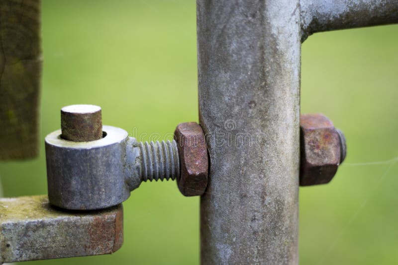 Rusty pivot hinge on farm gate providing access to farmland field in rural Hampshire with shallow depth of field. Rusty pivot hinge on farm gate providing access to farmland field in rural Hampshire with shallow depth of field