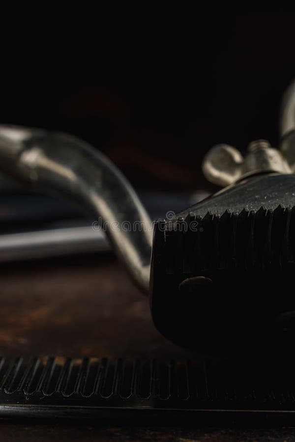 On a rusty surface manual clipper and comb. close up. rustic. vertical royalty free stock photography