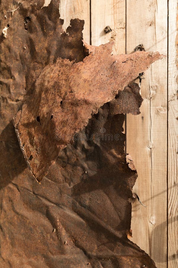 Rusty Twisted Sheet Metal on Wooden Plank Wall