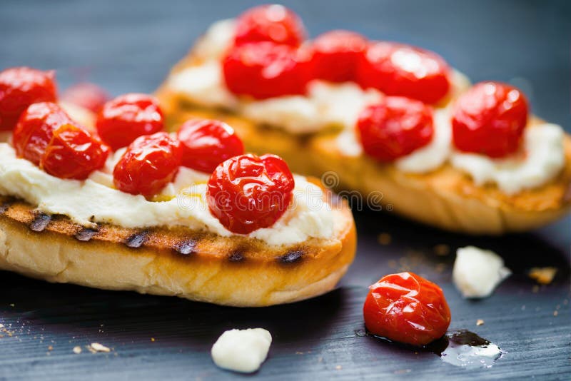 Rustycznie włoska bruszkata z karmelowanymi pomidorami wiśniowymi i serami ricotta fotografia stock