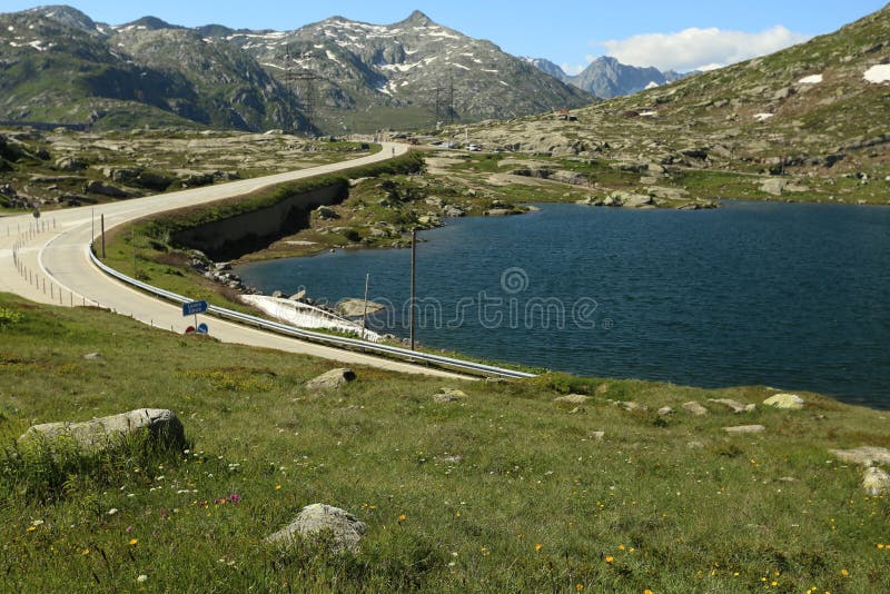 Beautiful scene on the road and Swiss Alps. When I`m watching on this road. I just want to sit in a car and have a ride throw this landscape. The Alps is a fantastic place, every time you there, you want to turn back. 
On a photo somewhere there`s snow, stones, green grass, blue sky, lake, meadow. Beautiful scene on the road and Swiss Alps. When I`m watching on this road. I just want to sit in a car and have a ride throw this landscape. The Alps is a fantastic place, every time you there, you want to turn back. 
On a photo somewhere there`s snow, stones, green grass, blue sky, lake, meadow.