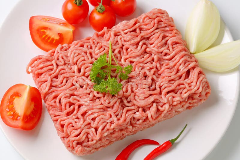 Raw ground pork and vegetables on plate. Raw ground pork and vegetables on plate
