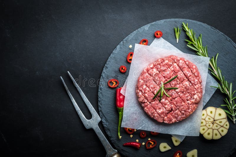 Ruwe hamburgerpasteitjes met kruiden en spicies royalty-vrije stock afbeelding Ruwe hamburgerpasteitjes met kruiden en spicies royalty-vrije stock afbeelding