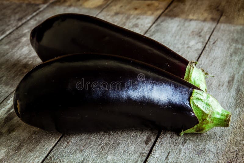 Ruwe organische aubergine twee op oude houten achtergrond stock afbeeldingen Ruwe organische aubergine twee op oude houten achtergrond stock afbeeldingen