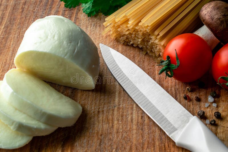 Ruwe spaghetti op een houten raad met gesneden mozarella, verse groenten, kruiden en paddestoelen stock foto's Ruwe spaghetti op een houten raad met gesneden mozarella, verse groenten, kruiden en paddestoelen stock foto's