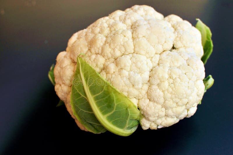 Ruwe verse witte bloemkool op zwarte achtergrond stock afbeelding Ruwe verse witte bloemkool op zwarte achtergrond stock afbeelding