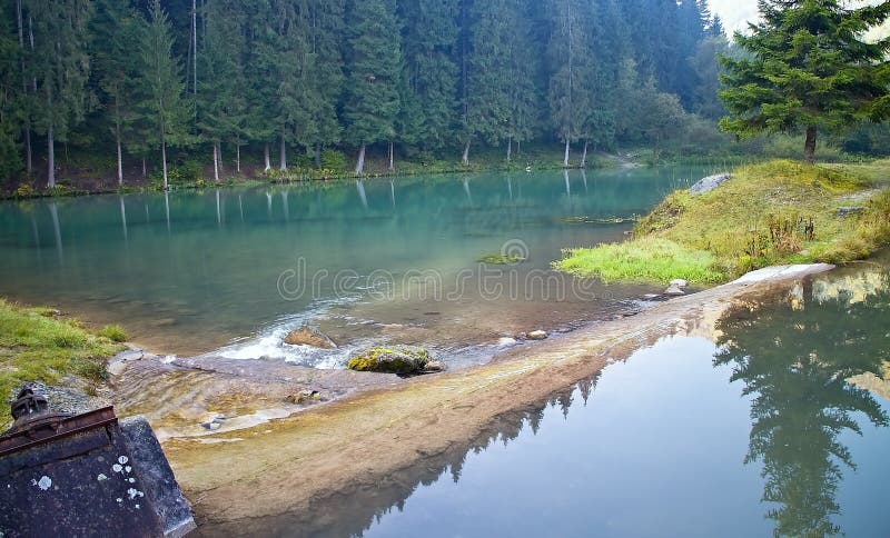 Ruzomberok - Cutkovska valley - rocks in a water reservoir with mirroring trees on the water surface.