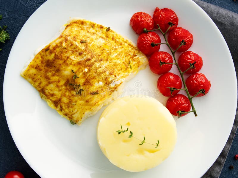 Rybi dorsz piec w piekarniku z puree ziemniaczane, pomidory, diety zdrowy jedzenie Zmrok - szary tło, odgórny widok fotografia stock Rybi dorsz piec w piekarniku z puree ziemniaczane, pomidory, diety zdrowy jedzenie Zmrok - szary tło, odgórny widok fotografia stock