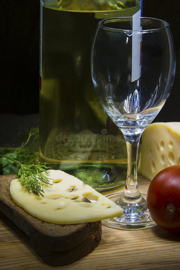 Rye bread with cheese, wine bottle and empty glass