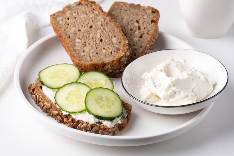 Rye Bread with Cream Cheese and Cucumbers on a White Table. Whole Grain