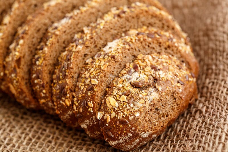 Rye Bread with Grains of Cereals on a Wooden Stand on a Wooden