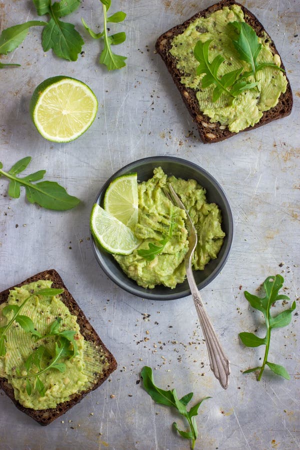 Rye brinda com guacamole e rúcula no fundo rústico foto de stock royalty free Rye brinda com guacamole e rúcula no fundo rústico foto de stock royalty free