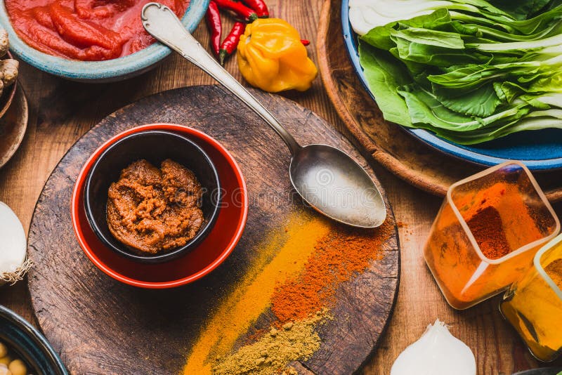 Curry paste with colorful spices , cooking spoon and ingredients, top view. Healthy eating or Indian cuisine concept. Curry paste with colorful spices , cooking spoon and ingredients, top view. Healthy eating or Indian cuisine concept