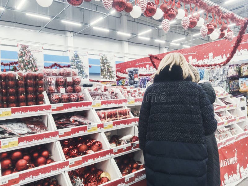 Ryssland Murmansk-November 10, 2018: folket väljer julleksaker för julgran i supermarket royaltyfri foto Ryssland Murmansk-November 10, 2018: folket väljer julleksaker för julgran i supermarket royaltyfri foto