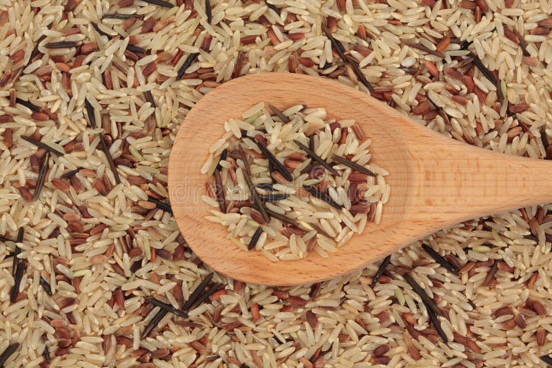 Wild rice in a wooden spoon and forming a background. Wild rice in a wooden spoon and forming a background.