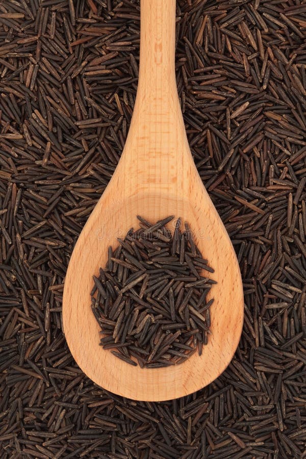 Wild rice in a wooden spoon and forming a background. Wild rice in a wooden spoon and forming a background.