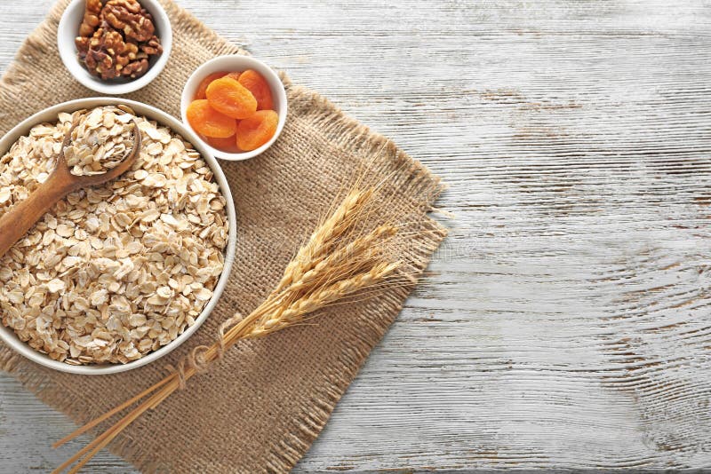 Rzuca kulą z oatmeal płatkami, wysuszonymi morelami i dokrętkami na drewnianym stole, zdjęcie stock Rzuca kulą z oatmeal płatkami, wysuszonymi morelami i dokrętkami na drewnianym stole, zdjęcie stock