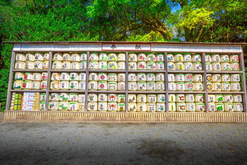 Kamakura, Japan - April 23, 2017: a lot of Japanese sake rice wine barrels with decorative writing in Tsurugaoka Hachiman Shinto shrine in Kamakura. Sake is an alcoholic beverage of Japanese. Kamakura, Japan - April 23, 2017: a lot of Japanese sake rice wine barrels with decorative writing in Tsurugaoka Hachiman Shinto shrine in Kamakura. Sake is an alcoholic beverage of Japanese.