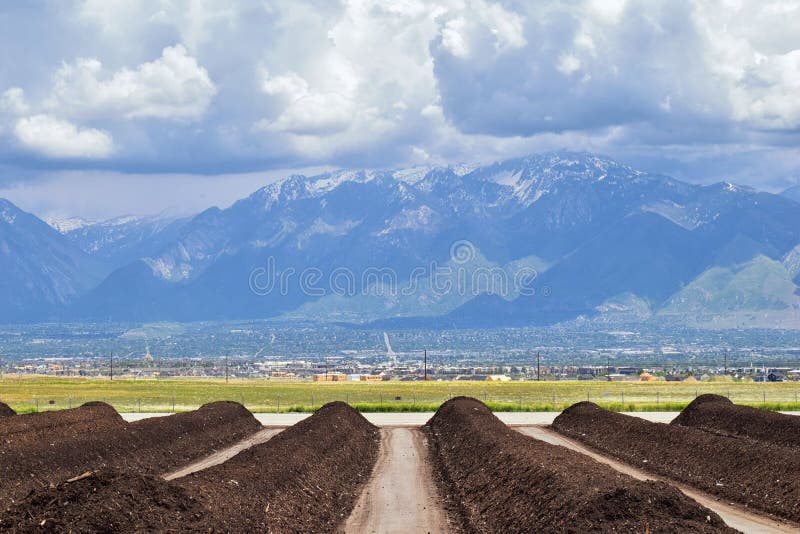 Rzędy Kompostowy przygotowywający dla sprzedaży z Panoramicznym widokiem Wasatch Frontowe Skaliste góry, Wielka Salt Lake dolina fotografia royalty free