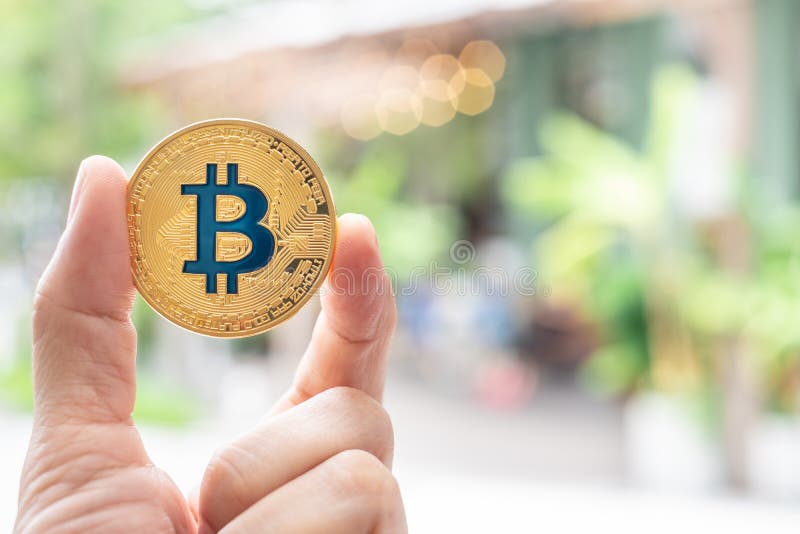 Räcka hållande guld- bitcoin som är främst av restaurang det accepterade b royaltyfria foton Räcka hållande guld- bitcoin som är främst av restaurang det accepterade b royaltyfria foton